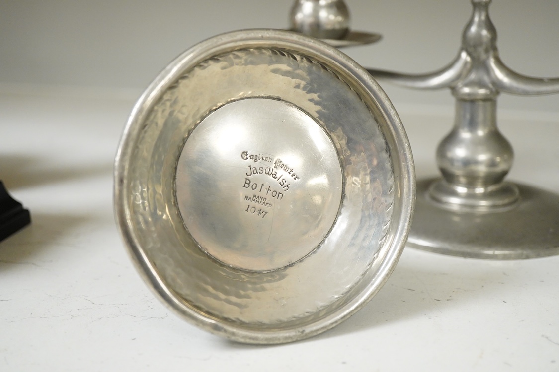 A Liberty Tudric pewter two branch candlestick, 22cm wide and two hammered candle holders.